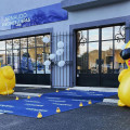 La devanture de BE SPA MAUBEC Arnaudo Everblue présente des ballons et des tapis promotionnels, soulignant la spécialité de l'entreprise dans la construction et la rénovation de piscines et vente de spas BE SPA, sous un ciel bleu clair.