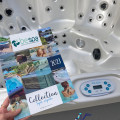 Magasin NORPISCINE, situé au 20, route nationale, 80150 Le Boisle. L'image montre une brochure de BE SPA Collection Spa rigide 2023 tenue devant un spa avec plusieurs jets et un panneau de commande de la marque be spa. Le logo de NORPISCINE est visible en bas de l'image avec l'adresse du magasin.