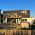 Façade extérieure de la boutique DBE85 à Saint Hilaire de Riez, Vendée, spécialisée dans la distribution des spas Be Spa. L'enseigne de la boutique est clairement visible, avec une vitrine élégante présentant des modèles de spas et des affiches publicitaires.